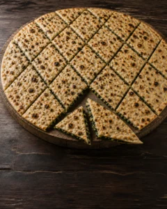 Eşkenar dörtgen dilimlere kesilmiş, pazı ve kırmızı soğan dolgulu geleneksel Hırvat böreği Poljički soparnik