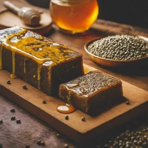 Tahta üzerinde bal gezdirilmiş koyu renkli helva dilimleri ve tohumlar