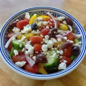 Desenli kâsede domates, salatalık, zeytin, soğan ve beyaz peynirli salata